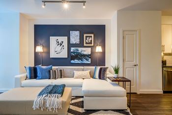 a living room with a blue accent wall and a white couch